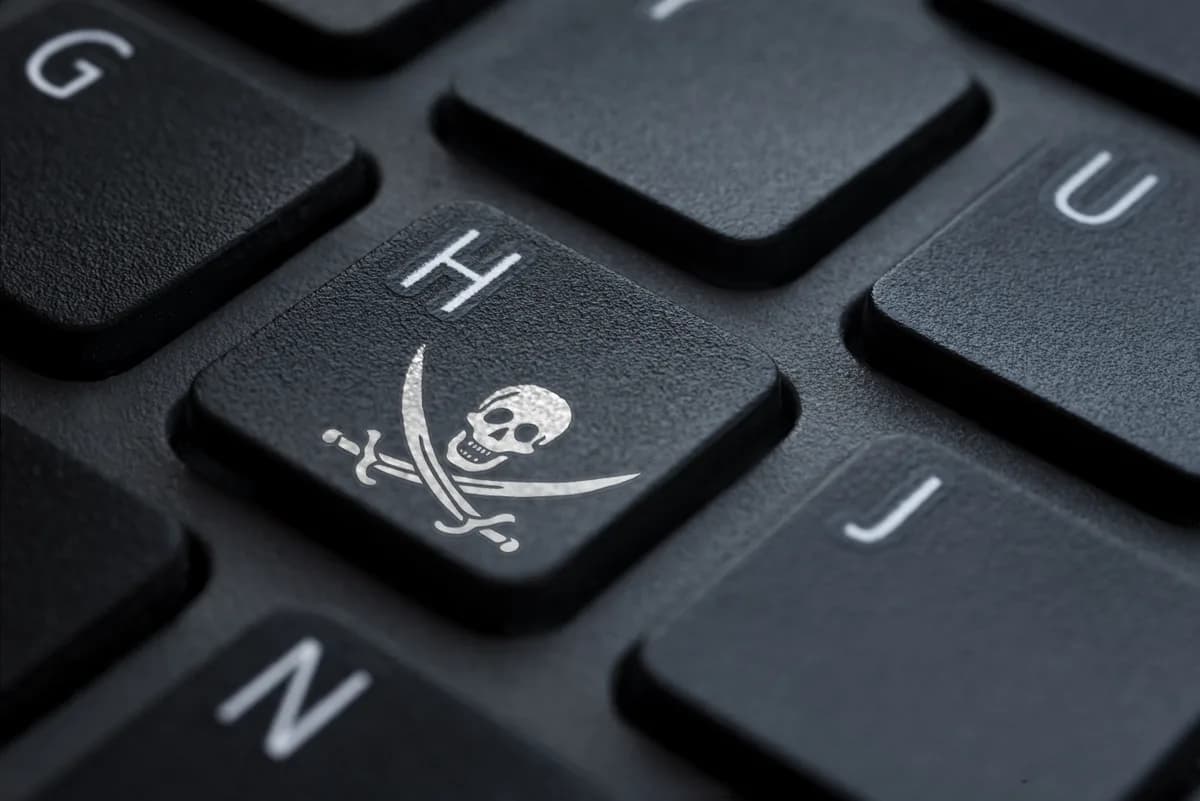 Site piraté que faire : touche de clavier avec symbole pirate (tête de mort et sabres croisés), illustration d'un site web victime de piratage